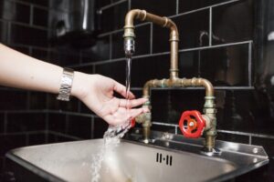 Cropped image of woman washing hands in sink at cafe washroom