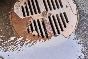 water draining into sewer manhole