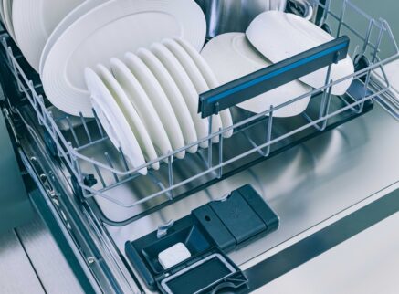 open dishwasher with clean white dishes
