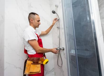 Workers are installing glass door of the shower enclosure. High quality photo