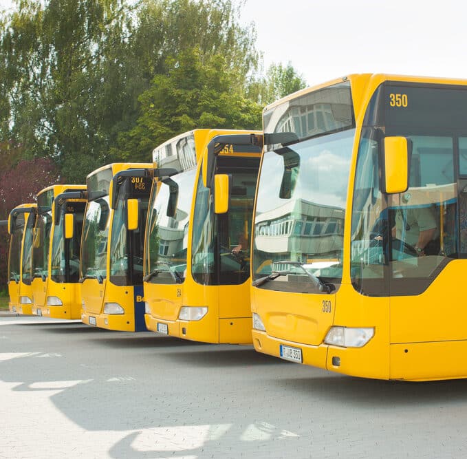 A row of yellow buses parked at a station