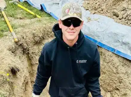 Spartan Plumbing plumber working in an excavated sewer line trench in Tacoma