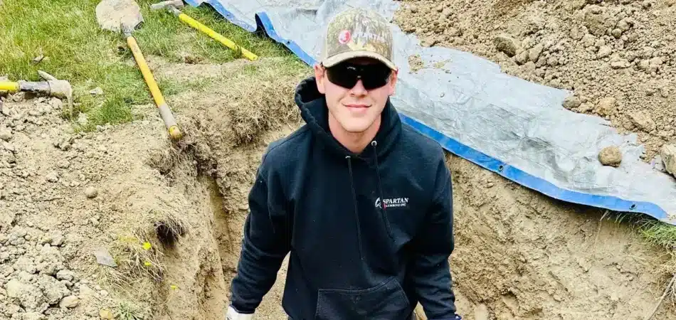 Spartan Plumbing plumber working in an excavated sewer line trench in Tacoma